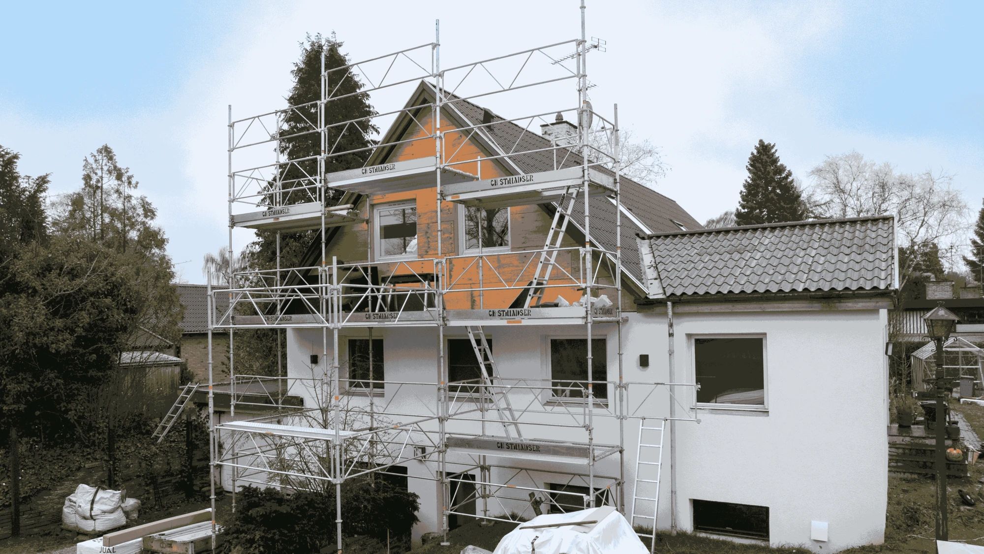 Parcelhus med stillads hele vejen op om gavlen under facaderenovering